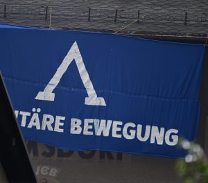 Foto einer blauen Flagge mit aufgemaltem Lambda und Schriftzug der Identitären Bewegung